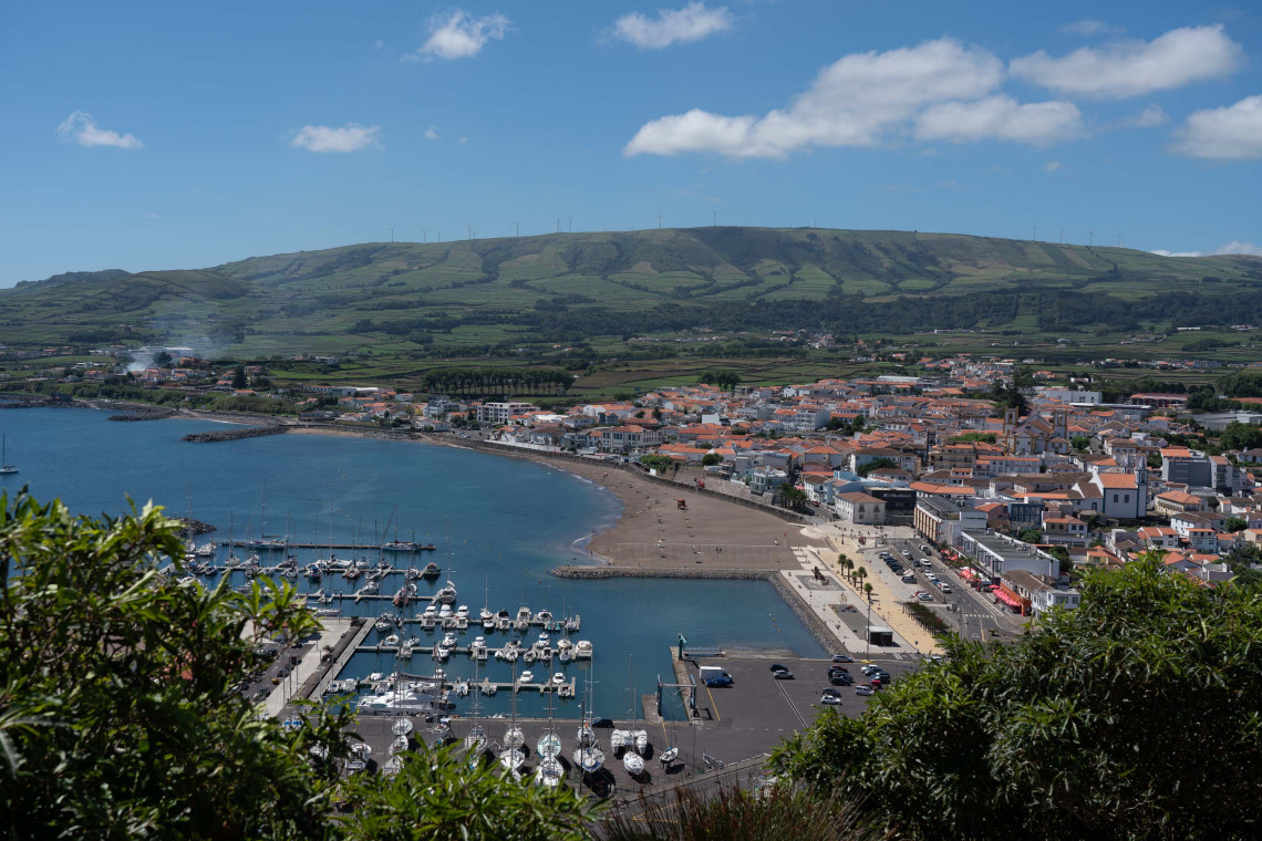 Panoramic view from Miradouro do Facho overlooking Praia da Vit&oacute;ria, with the marina, sandy beach, city and green hills surrounding the bay.