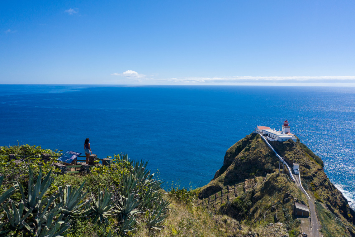 Panoramic view of Gon&ccedil;alo Velho Lighthouse perched on a steep coastal cliff at Ponta do Castelo on Santa Maria Island, surrounded by the deep blue Atlantic Ocean.