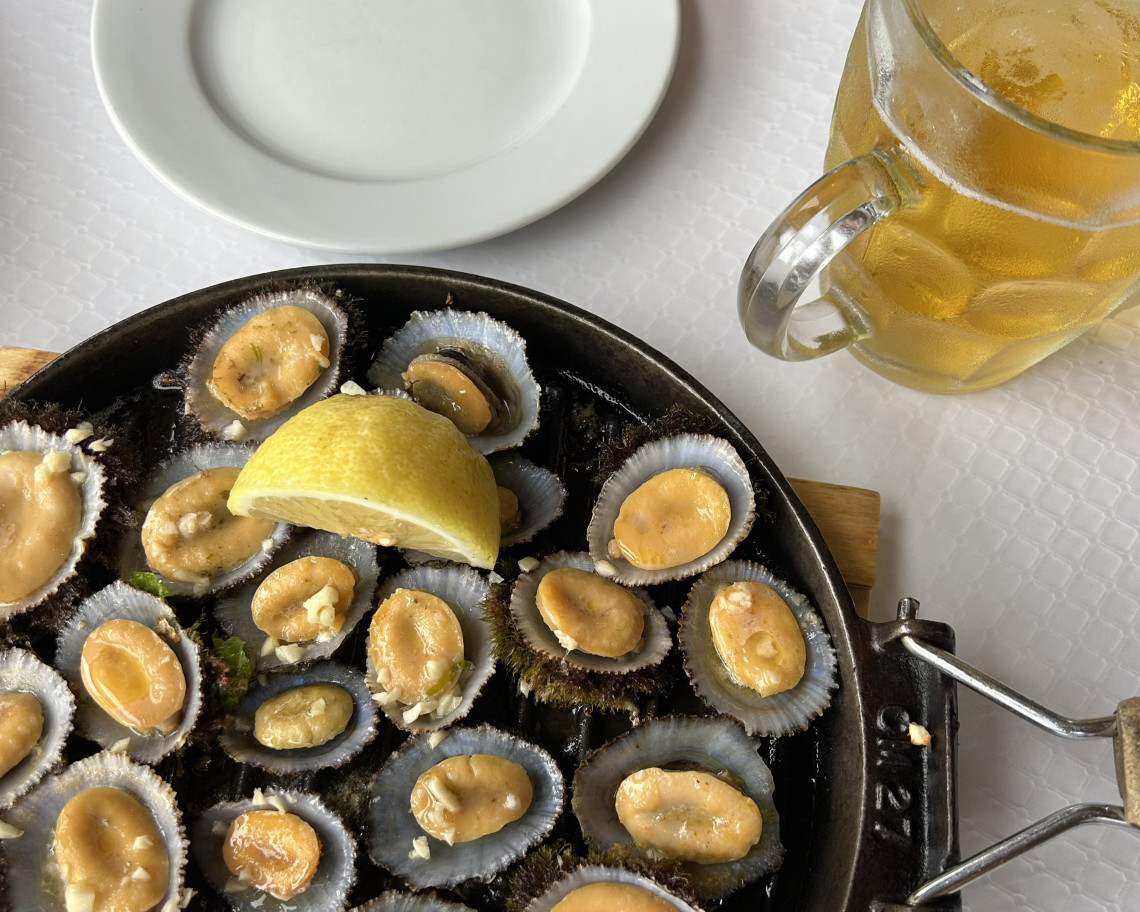Pan of grilled limpets served with lemon on Graciosa Island, a traditional Azorean seafood dish prepared from shellfish harvested along the volcanic Atlantic coast.
