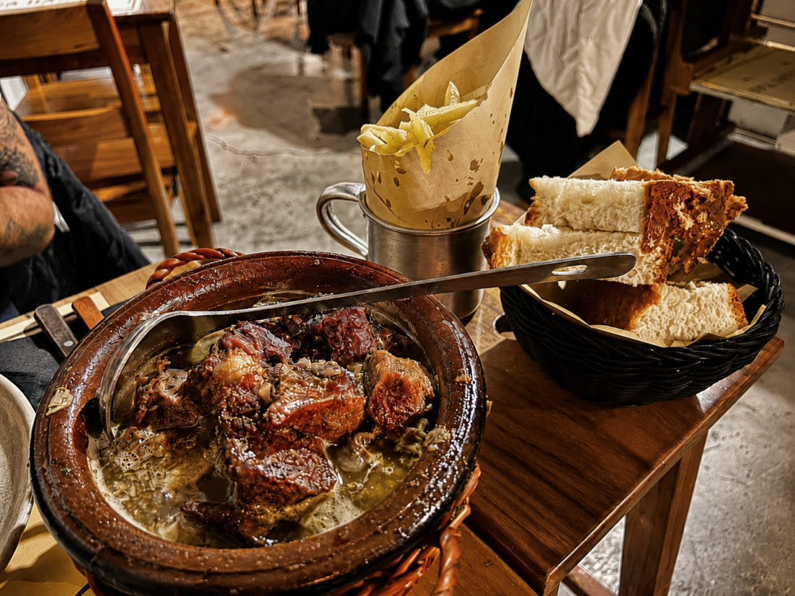 Traditional alcatra da Terceira served in a clay pot with slow-cooked beef, accompanied by bread and French fries. This meat dish is one of the best-known specialties of Terceira Island.