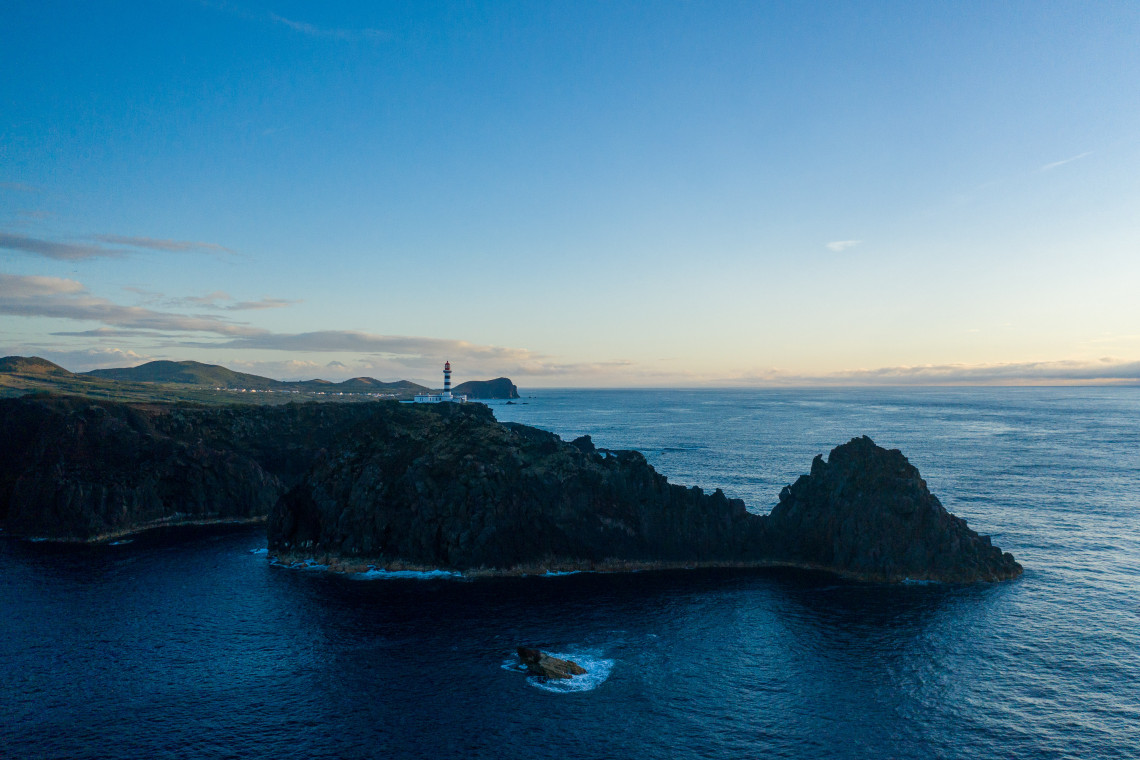 Aerial view of the rugged Ponta da Barca coastline on Graciosa Island, with Ponta da Barca Lighthouse and the volcanic formations surrounding Ilh&eacute;u da Baleia.
