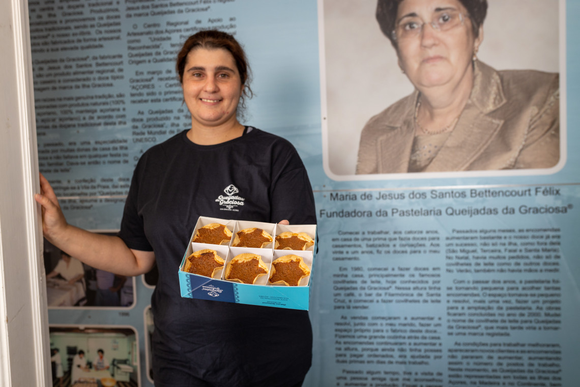 Local producer holding a box of Queijadas da Graciosa, the island&rsquo;s traditional star-shaped pastries with a thin pastry shell and sweet filling.
