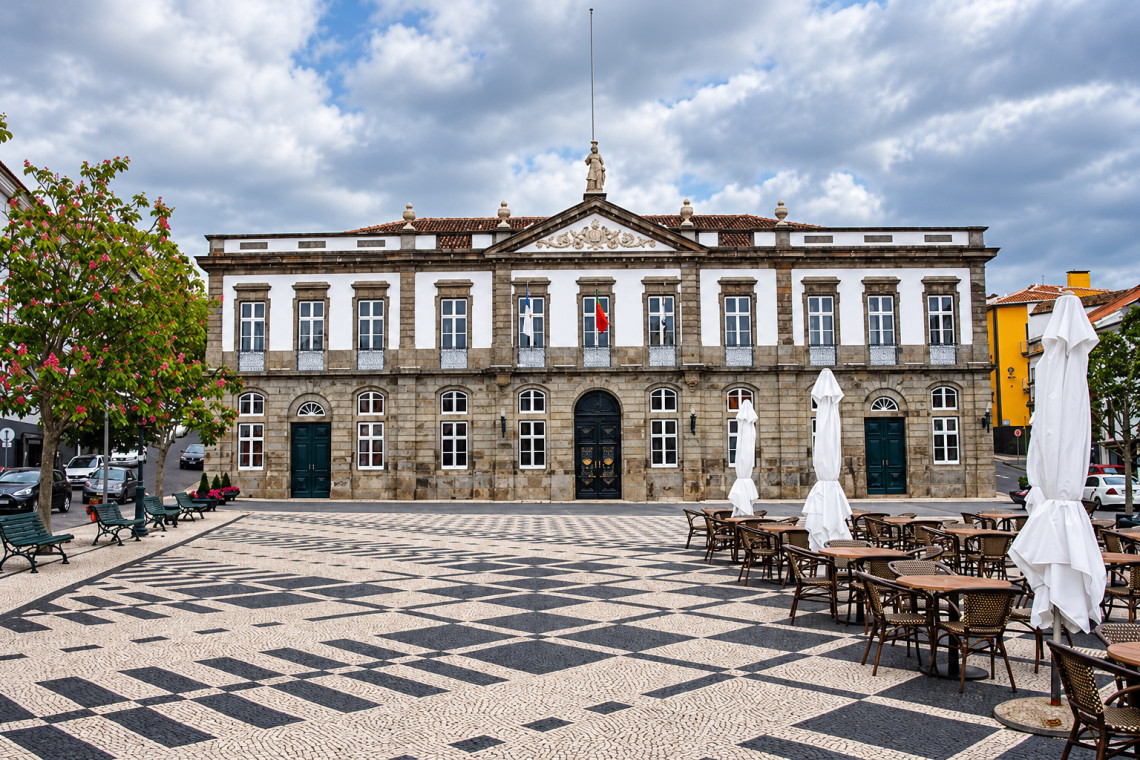Historic Pa&ccedil;os do Concelho in Angra do Hero&iacute;smo facing Pra&ccedil;a Velha, with its symmetrical stone fa&ccedil;ade, tall windows and Portuguese pavement across the square.