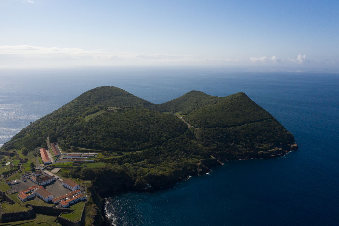 Aerial view of Fortaleza de S&atilde;o Jo&atilde;o Baptista on Monte Brasil, showing the historic military complex enclosed by green volcanic slopes beside the Atlantic coast.