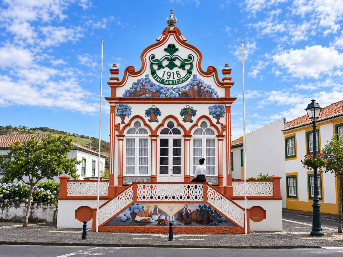 Traveler standing in front of the Imp&eacute;rio do Divino Esp&iacute;rito Santo de S&atilde;o Sebasti&atilde;o on Terceira Island, distinguished by its ornate white-and-red fa&ccedil;ade, floral decoration and 1918 inscription.