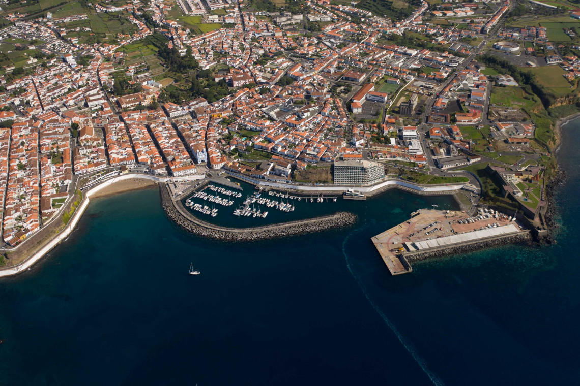 Aerial view of Prainha in Angra do Hero&iacute;smo on Terceira Island, Azores, showing the sheltered beach, marina and waterfront area along the Atlantic coast.