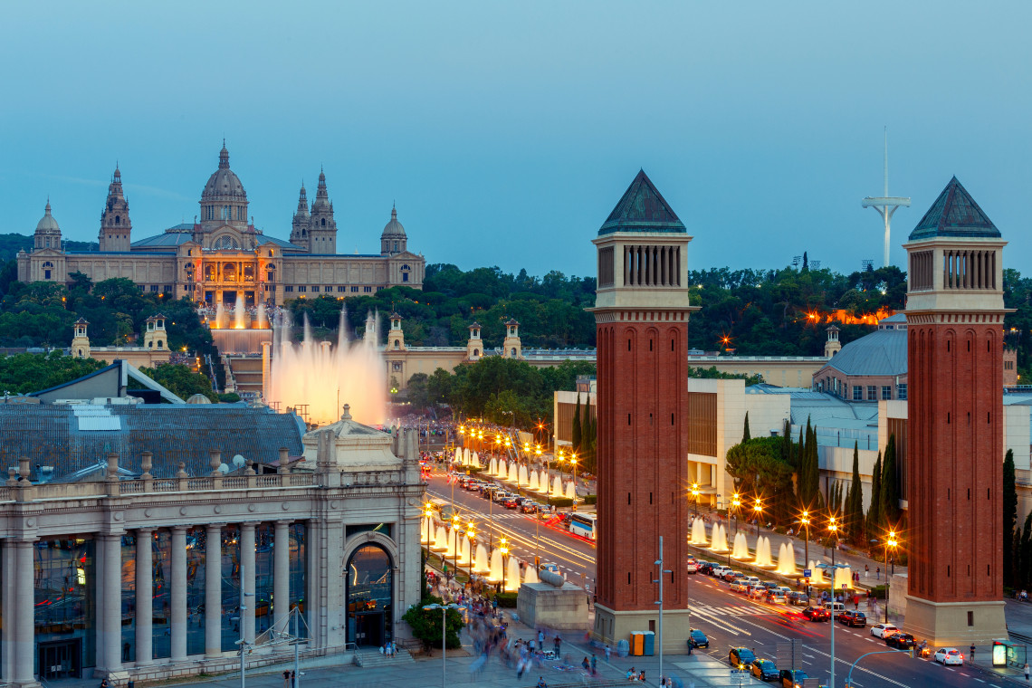Barcelona's Pla&ccedil;a d'Espanya illuminated at dusk, Venetian Towers and Palau Nacional in view