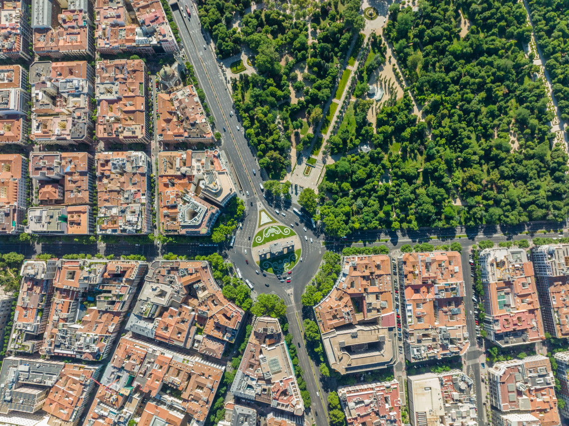Aerial view of Madrid showing dense residential blocks bordering the green expanse of Retiro Park