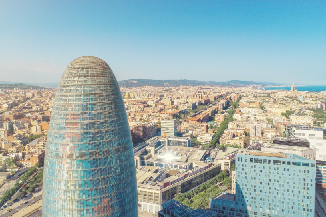 Torre Gl&ograve;ries rises above Barcelona, Spain, with the city&rsquo;s residential districts, surrounding hills and Mediterranean coastline extending into the distance.