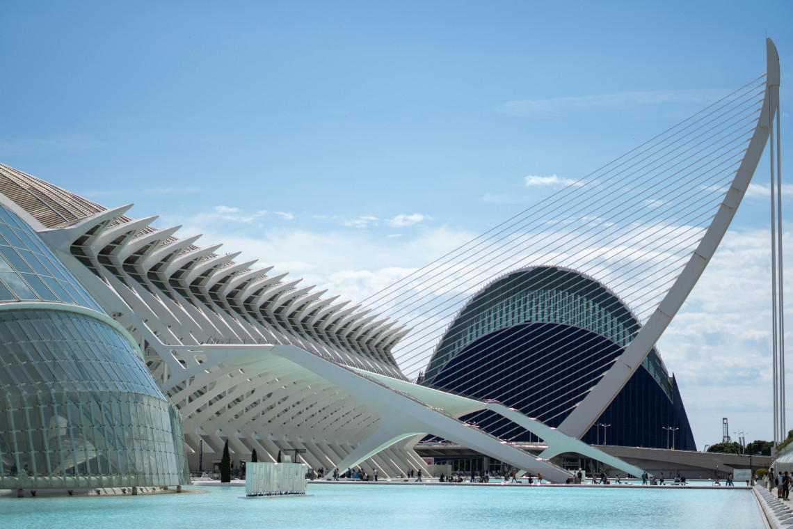 The City of Arts and Sciences in Valencia, Spain, features white structural arches, the Assut de l&rsquo;Or Bridge and the curved L&rsquo;&Agrave;gora building. The architectural complex is reflected in the surrounding turquoise pool.