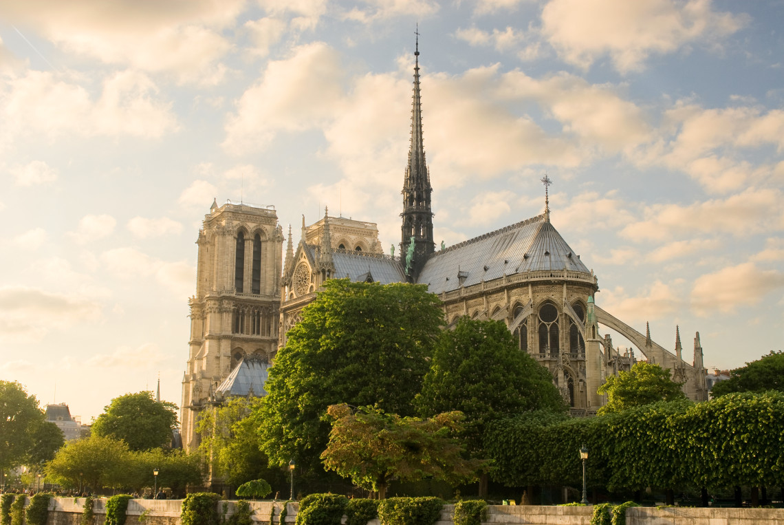 Notre-Dame Cathedral in Paris, France, with its Gothic facade and towers reflected in the Seine