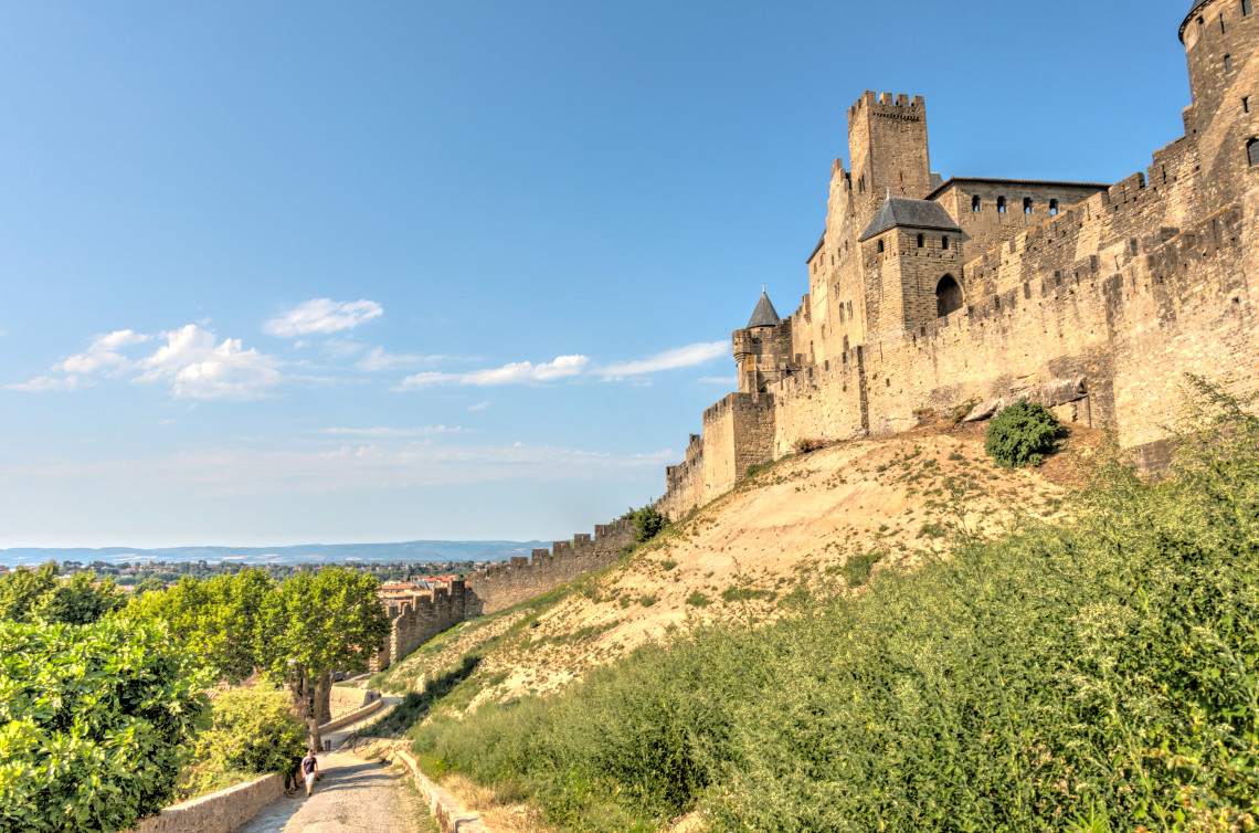 Aerial view of the medieval walled city of Carcassonne with double ramparts and towers at dusk, Languedoc, France