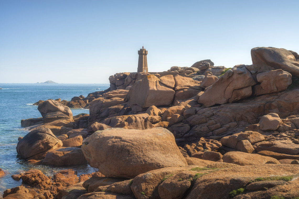 Mean Ruz red and white striped lighthouse on the Pink Granite Coast near Ploumanach, Brittany, France