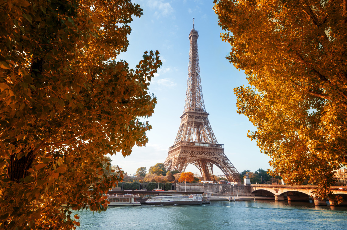 Eiffel Tower framed by golden autumn trees along the Seine River in Paris, France