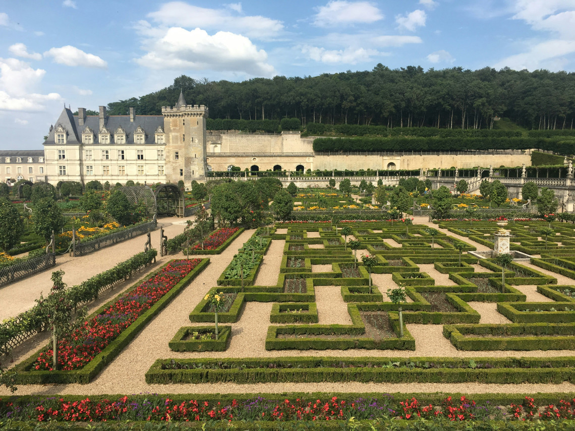 The geometric ornamental kitchen gardens of Chateau de Villandry with neatly clipped boxwood hedges colorful flowers and the Renaissance chateau in the background in the Loire Valley France