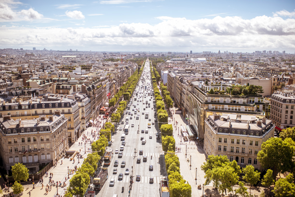 Aerial view of the Champs-Elysees boulevard with heavy traffic stretching toward the city center, seen from the Arc de Triomphe, Paris, France