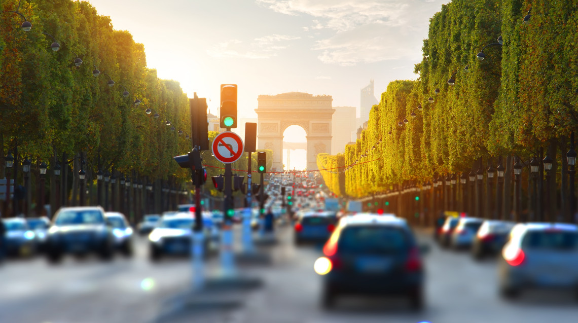 Heavy car traffic on the Champs-Elysees boulevard toward the Arc de Triomphe at golden hour, Paris, France