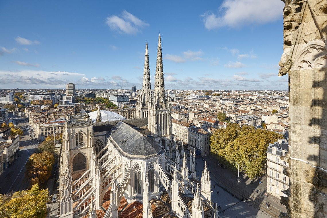 Aerial view of the Gothic Saint-Andre Cathedral twin spires rising above the rooftops of Bordeaux city center, France