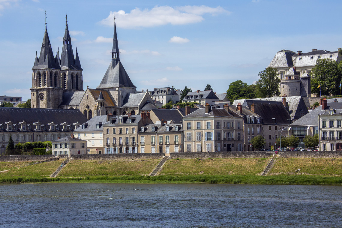 Gothic church towers and historic buildings of Blois reflected along the Loire River waterfront, Loire Valley, France