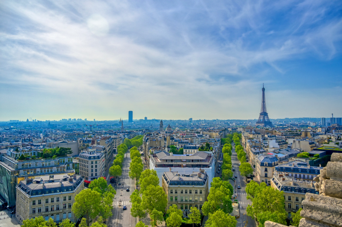 Panoramic aerial view of Paris boulevards radiating from the Arc de Triomphe with the Eiffel Tower and Montparnasse Tower on the skyline, France