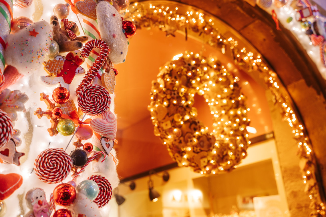 Close-up of festive Christmas decorations and illuminated ornaments at the Strasbourg Christmas Market in Strasbourg, France. Warm lights, handcrafted decorations, and seasonal displays create a traditional holiday atmosphere.