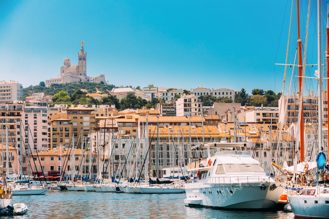 Sailboats and yachts in the Vieux-Port of Marseille with the Basilica of Notre-Dame de la Garde on the hill above the city, Provence, France