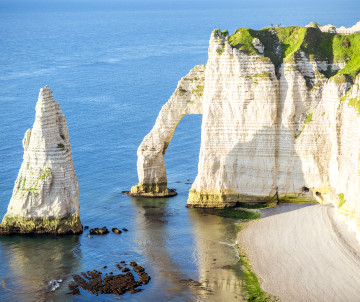 White chalk cliffs with natural arch and needle rock formation at Etretat on the Normandy coast, France