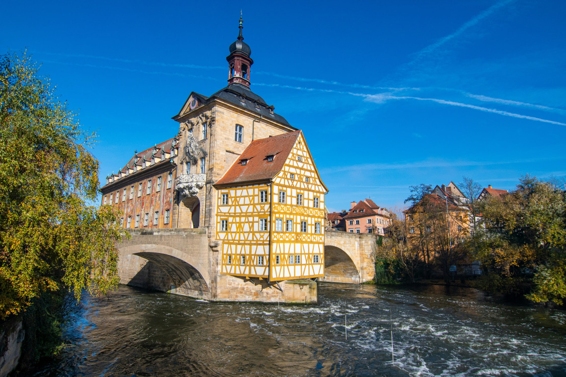 Bamberg&rsquo;s historic Old Town Hall stands on a bridge over the Regnitz River, featuring its distinctive half-timbered fa&ccedil;ade and Baroque architecture.