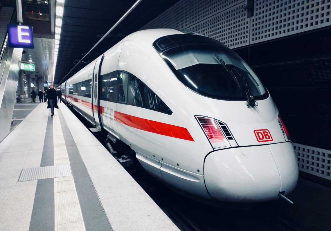 White Deutsche Bahn ICE high-speed train with its distinctive red stripe waiting at a railway station in Germany.