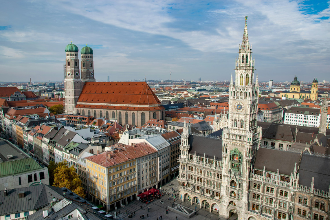 Elevated view over Munich&rsquo;s Marienplatz, with the ornate Neues Rathaus and the twin towers of the Frauenkirche dominating the historic city center.