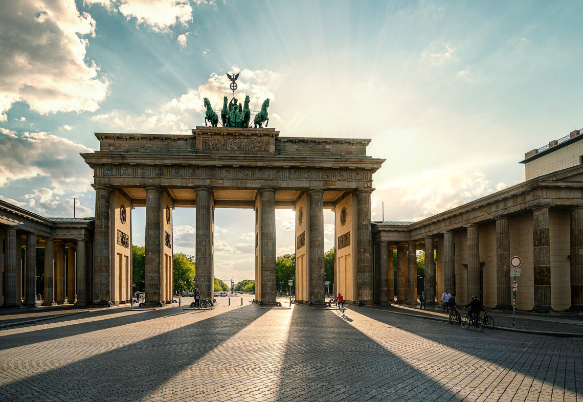 Brandenburg Gate illuminated by warm sunlight, with its neoclassical columns and Quadriga sculpture overlooking Pariser Platz.