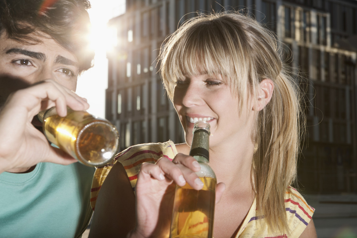 Young travelers enjoy bottled beer together in an urban setting, representing Cologne&rsquo;s well-known K&ouml;lsch beer culture and nightlife.