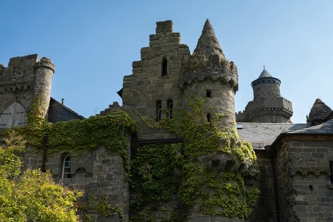 Ivy-covered stone towers and medieval-style architecture of L&ouml;wenburg Castle in Bergpark Wilhelmsh&ouml;he, Kassel.