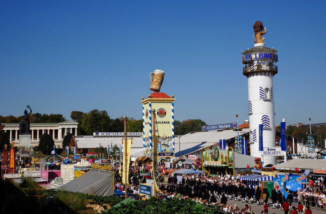 Crowds gather among beer tents, festival signs and amusement attractions at Oktoberfest on the Theresienwiese grounds in Munich, Germany.