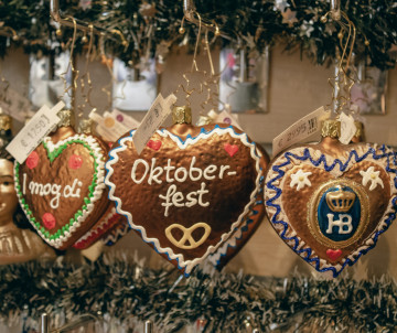 Decorated gingerbread hearts hang from a market stall at Oktoberfest in Munich, Germany. The colourful iced designs include German phrases and Bavarian beer symbols.