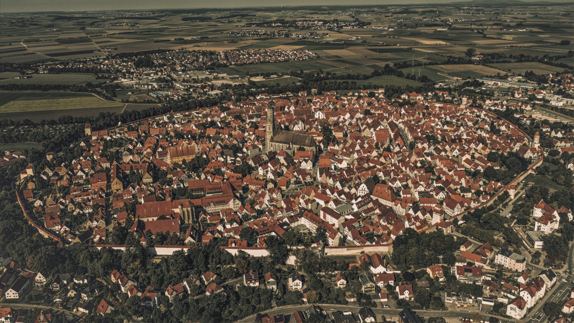Aerial view of N&ouml;rdlingen showing its compact medieval old town, red-tiled rooftops and complete historic city walls surrounded by countryside.