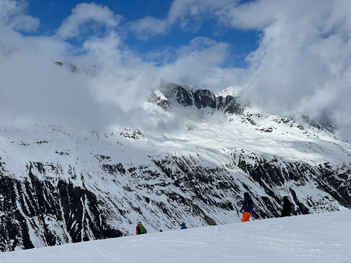 Skiers cross the snow-covered terrain of the Obergurgl-Hochgurgl ski area in Obergurgl, Austria. Low clouds drift around the surrounding &Ouml;tztal Alps.