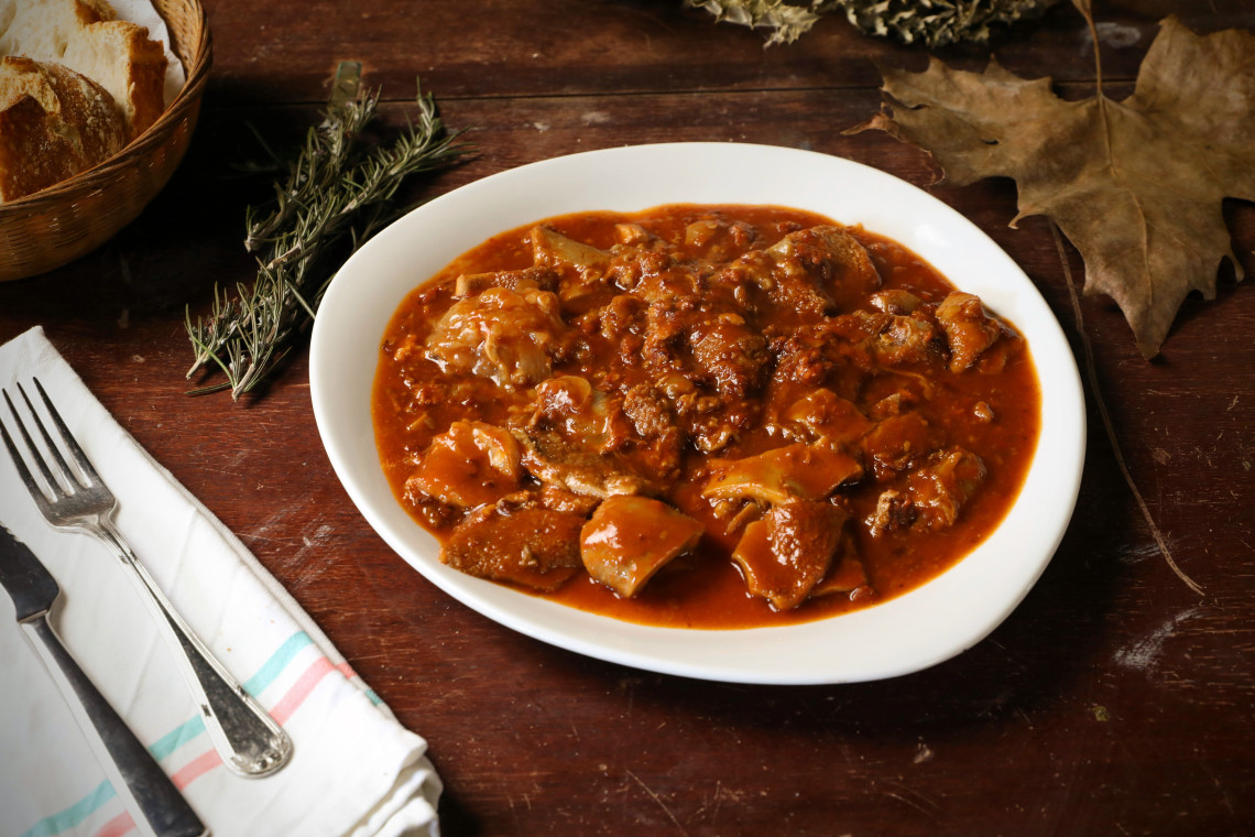 Traditional Beuschel served in Vienna, Austria, with pieces of veal lung and heart in a thick savoury sauce. Bread, rosemary and autumn leaves surround the white serving dish.