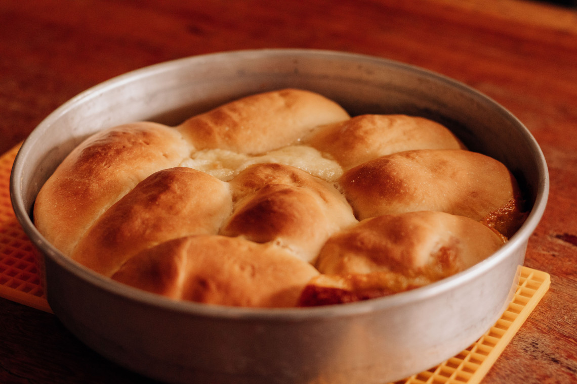 Traditional Austrian Buchteln are baked together in a round metal pan in Vienna, Austria. The golden sweet buns are commonly filled with plum jam and served with vanilla sauce.