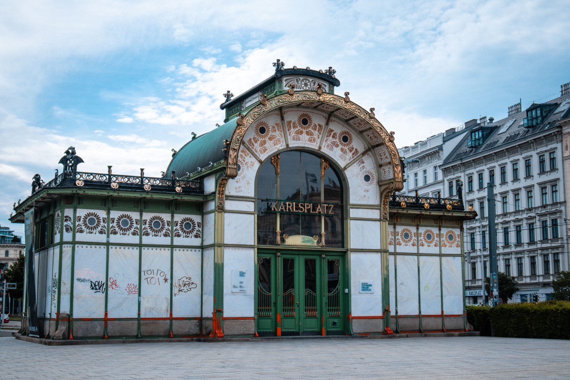 The Otto Wagner Karlsplatz Pavilion in Vienna, Austria, features a green domed roof, floral ornamentation and symmetrical Art Nouveau architecture. The historic former railway entrance stands beside Karlsplatz.