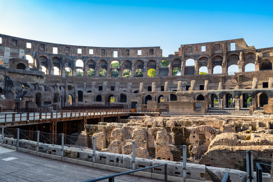 Detailed view inside the Colosseum in Rome, Italy, showing the exposed hypogeum and surrounding tiers of ancient arches. The underground network once supported the spectacles held in the Roman amphitheatre.