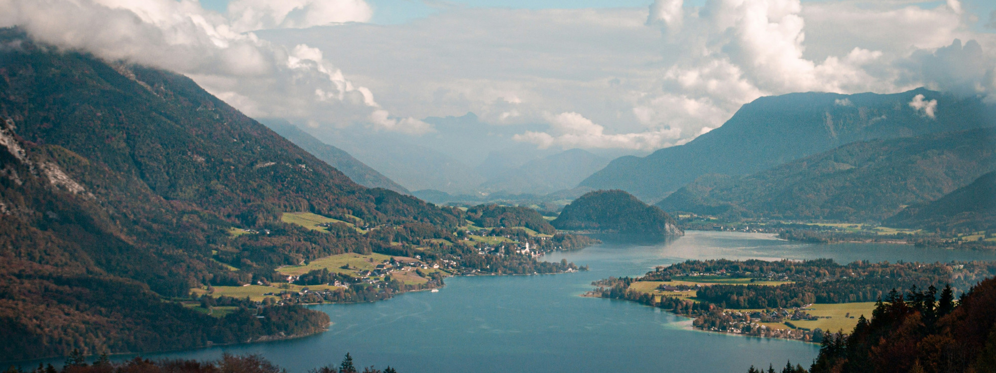Panoramic view of Hallstätter See in Austria’s Salzkammergut region, surrounded by steep Alpine mountains, forests and lakeside villages.