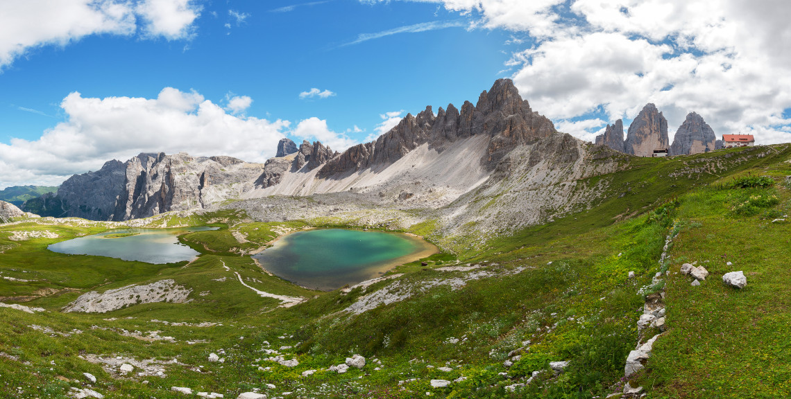 Panoramic view of Laghi dei Piani alpine lakes surrounded by rocky Dolomite peaks with Rifugio Locatelli mountain refuge and Tre Cime di Lavaredo visible, South Tyrol, Italy