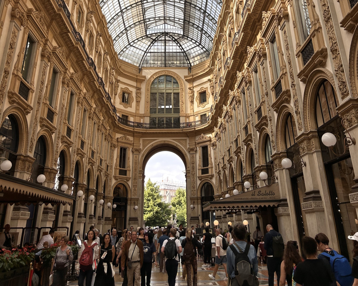 Crowds of tourists walking through the ornate glass vaulted Galleria Vittorio Emanuele II shopping arcade with luxury boutiques, Milan, Lombardy, Italy