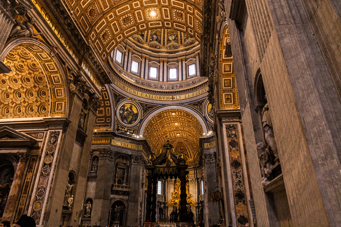 Interior of St. Peter's Basilica looking toward the ornate Baroque dome and Bernini's bronze baldachin over the papal altar, Vatican City, Rome, Italy