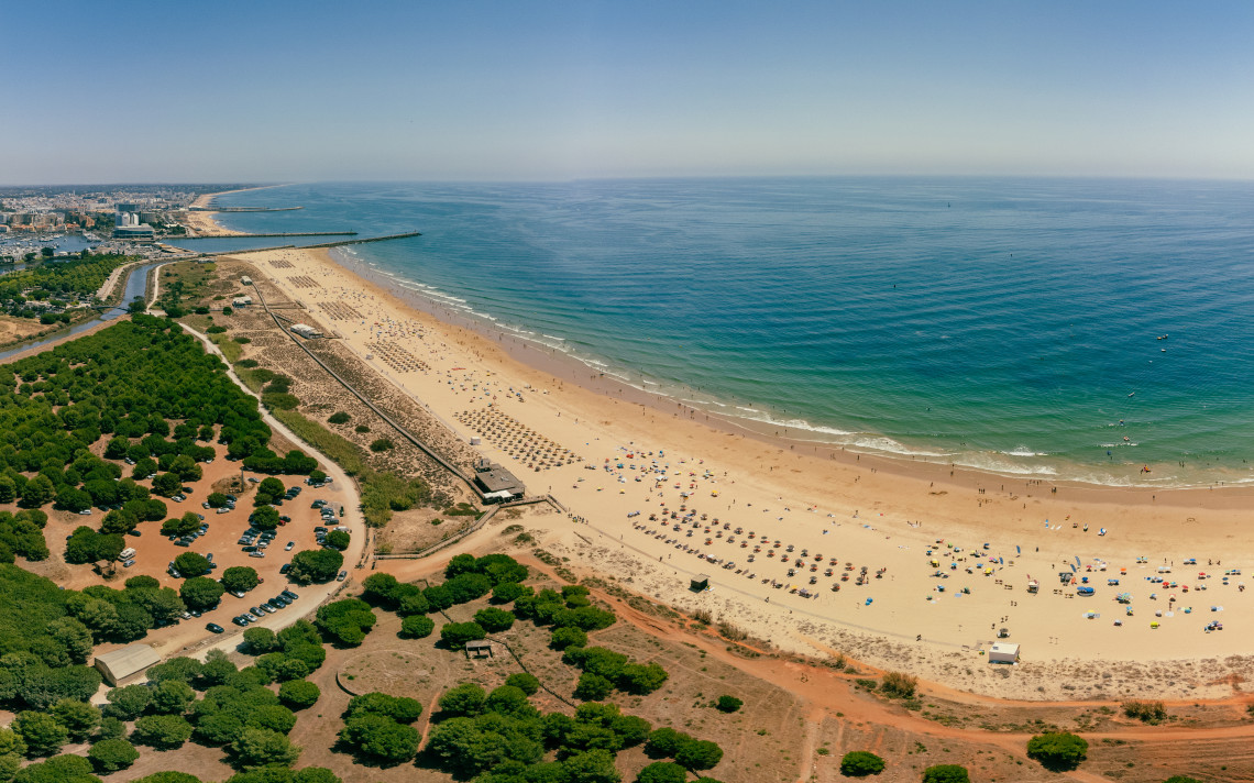 Aerial view of Praia da Fal&eacute;sia near Vilamoura, showing a long sandy beach, turquoise Atlantic waters and the coastal landscape of the central Algarve.