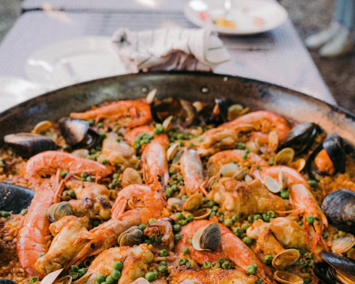 Seafood rice served in a large pan in the Algarve, Portugal, topped with prawns, mussels, clams, peas and fresh herbs. The dish reflects the region&rsquo;s strong connection to Atlantic seafood and coastal cuisine.