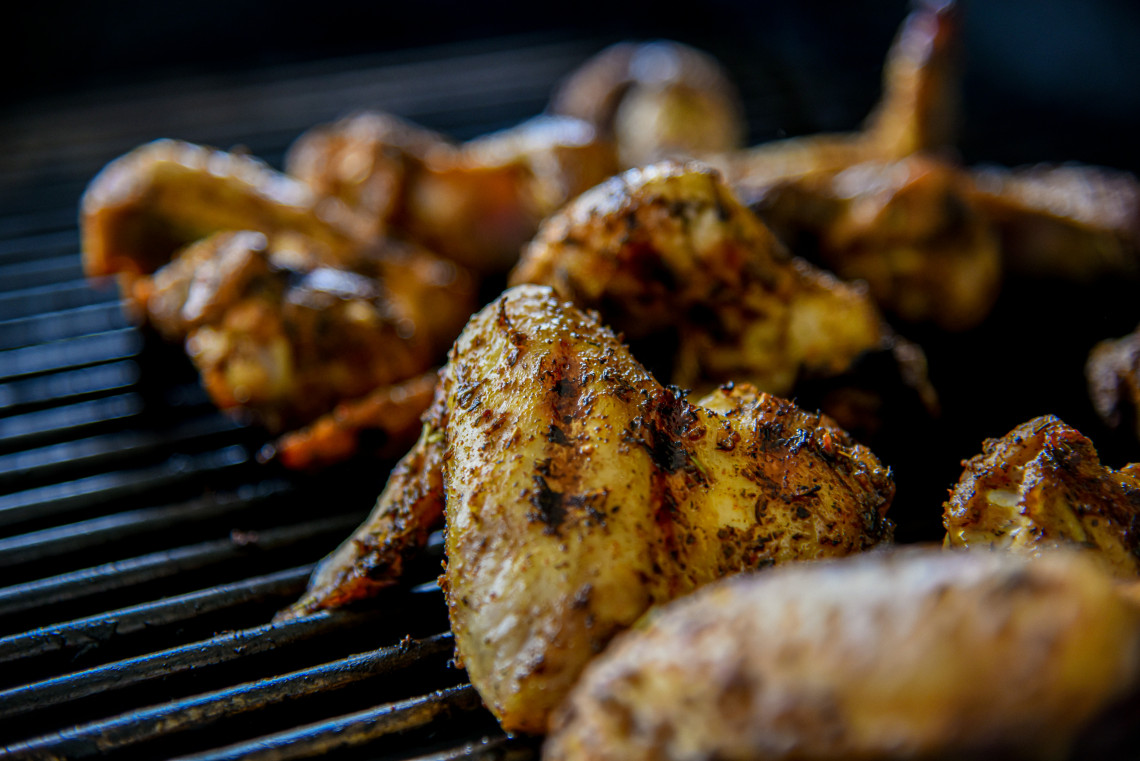 Pieces of piri-piri chicken grilling over charcoal in the Algarve, Portugal, with browned skin and visible seasoning. This traditional Portuguese dish is closely associated with the Algarve&rsquo;s regional cuisine.