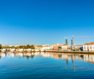 View of the Marina de Lagos waterfront in Lagos, Algarve, Portugal, featuring calm waters, whitewashed buildings, and reflections along the marina. The image showcases one of the main leisure and boating areas in Lagos, close to the historic town center a